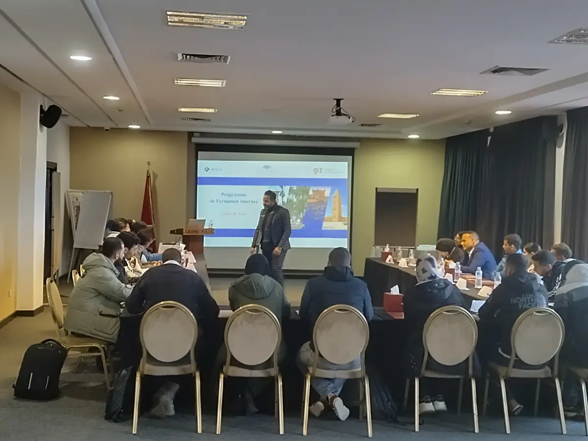 Trainer presenting to a group during an interpreted training session in Morocco